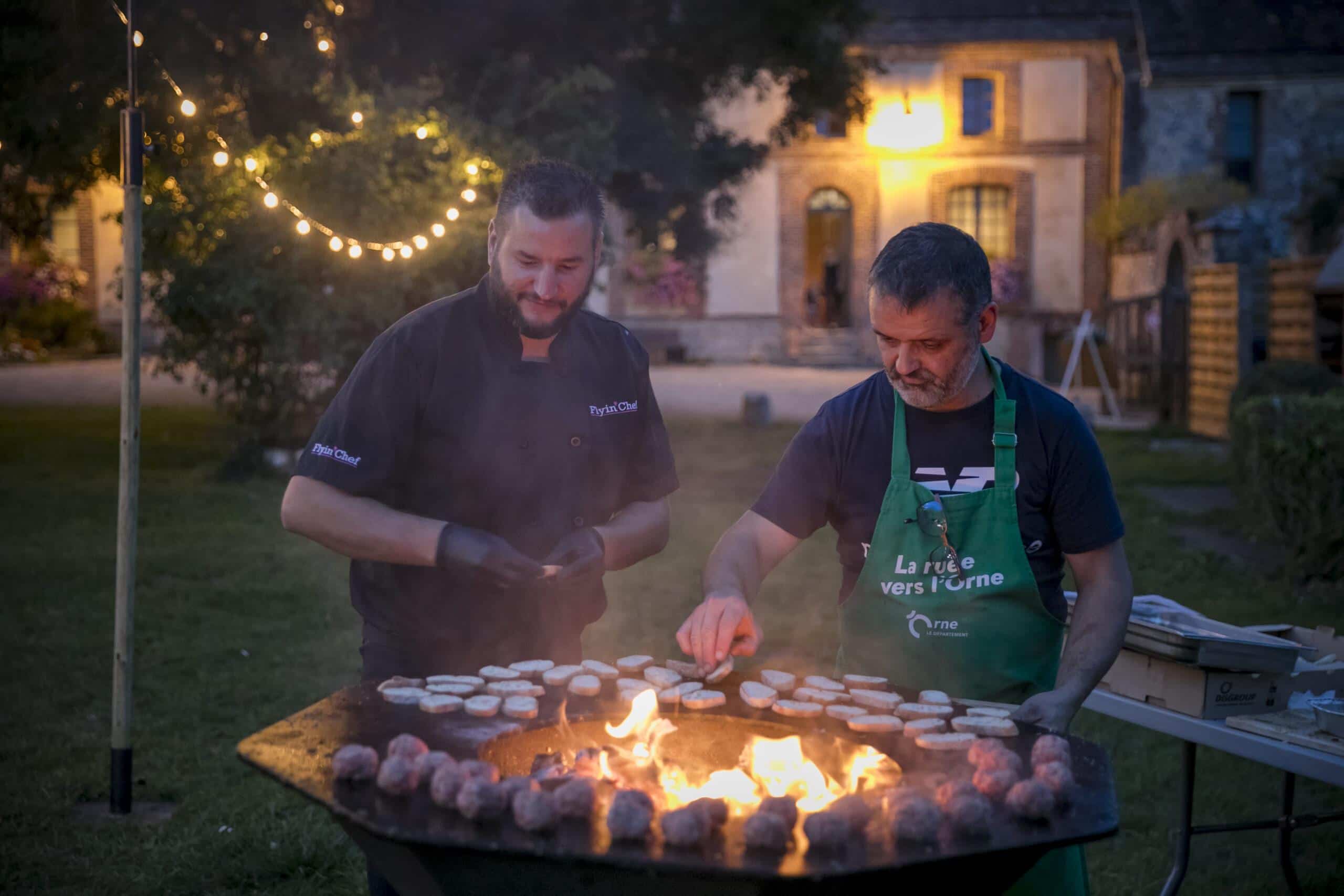 Show culinaire au brasero au crépuscule lors d'un festival orchestré par Flyin'Chef