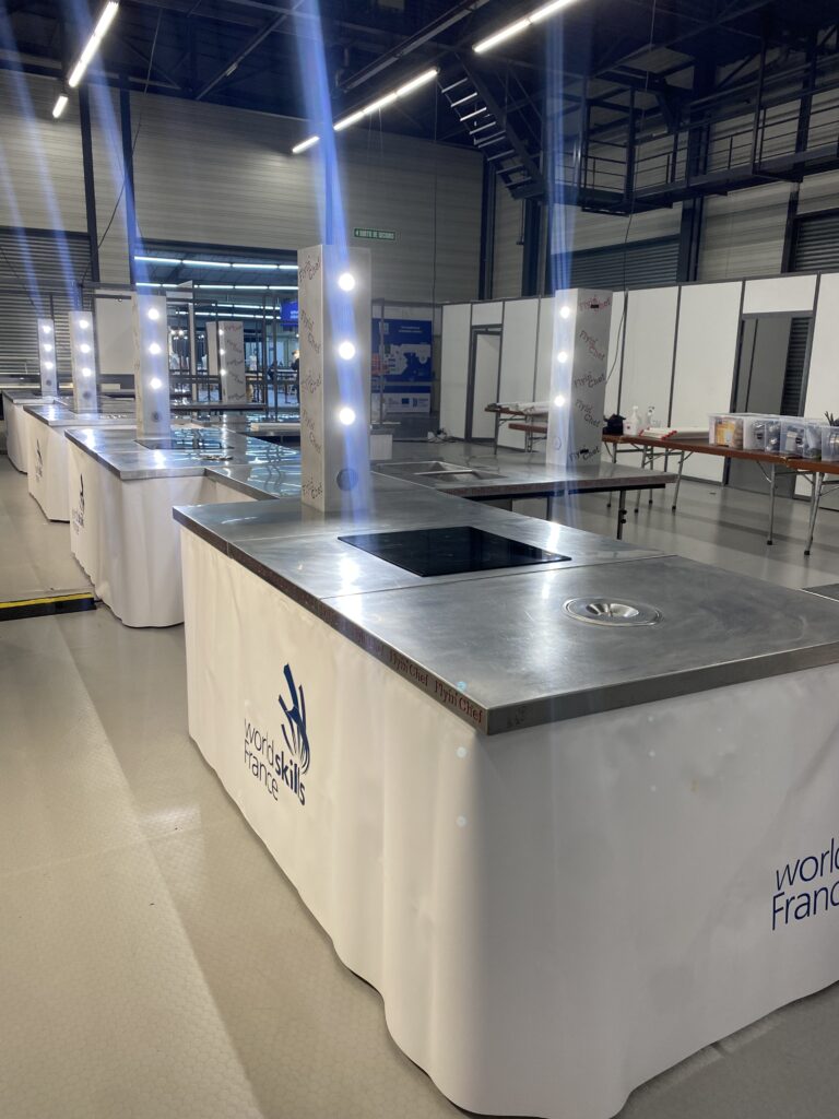Postes de compétition vides et prêts, faisceaux de lumière sur les tours Flyin'Chef, la veille d'une épreuve