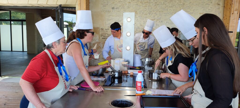 Équipe en toques et tabliers autour d'un plan de cuisson lors d'un team building culinaire