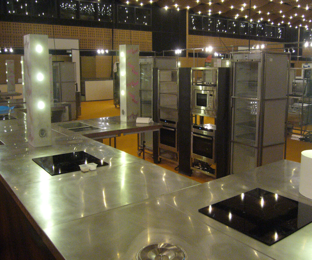 Postes inox installés de nuit sous les guirlandes, tours lumineuses Flyin'Chef, avant les épreuves des Olympiades des Métiers