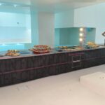 Buffet dressé sur la ligne de cuisine mobile éclairée dans une salle de réception
