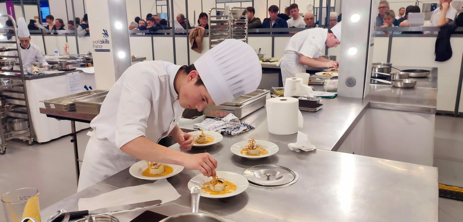 Un candidat dresse son assiette sur un poste Flyin'Chef aux sélections WorldSkills d'Angers