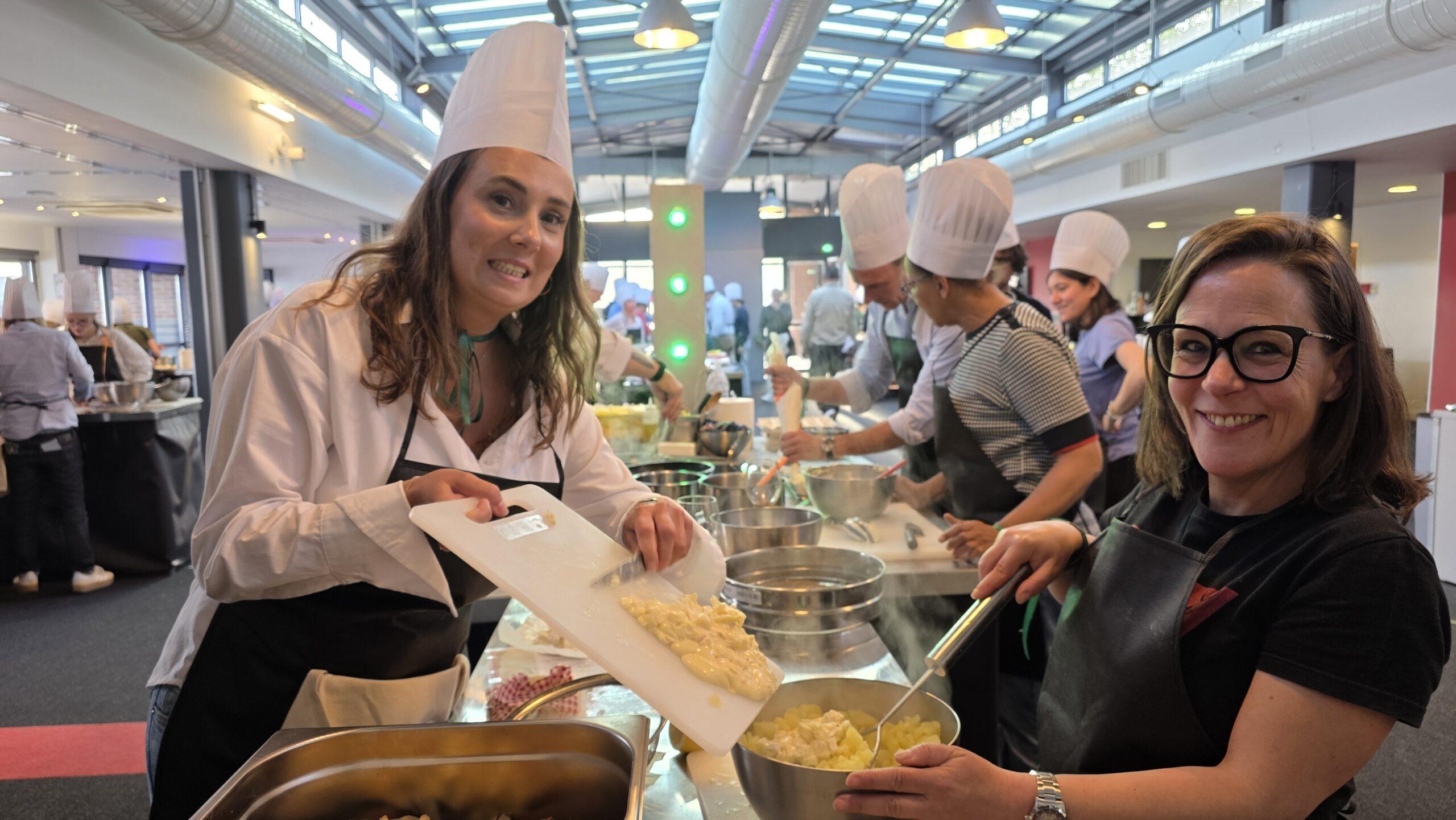 Participantes en toque préparant une recette pendant le team building culinaire Paris-Normandie à Rouen