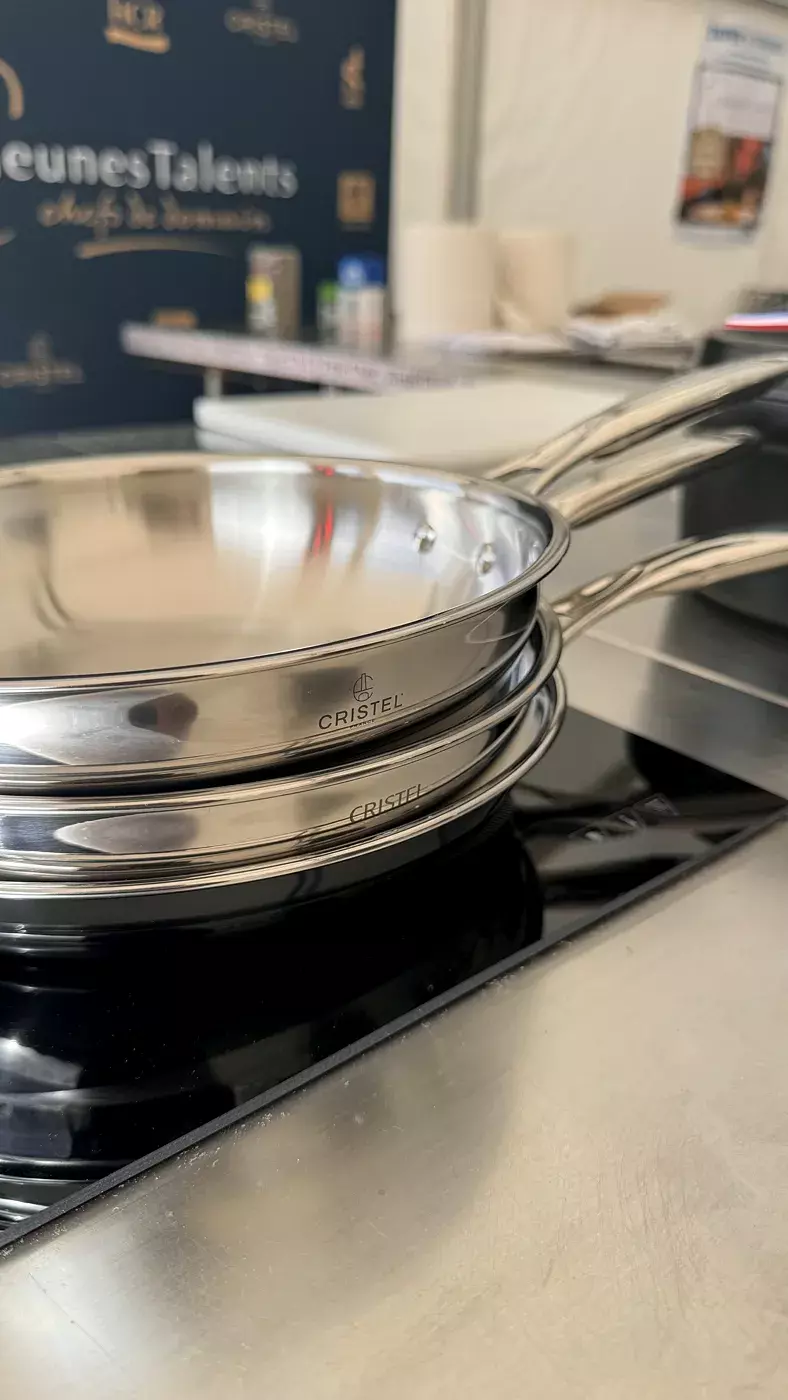 Poêles Cristel posées sur une plaque à induction d'un poste de cuisine du Concours Jeunes Talents à Saulieu
