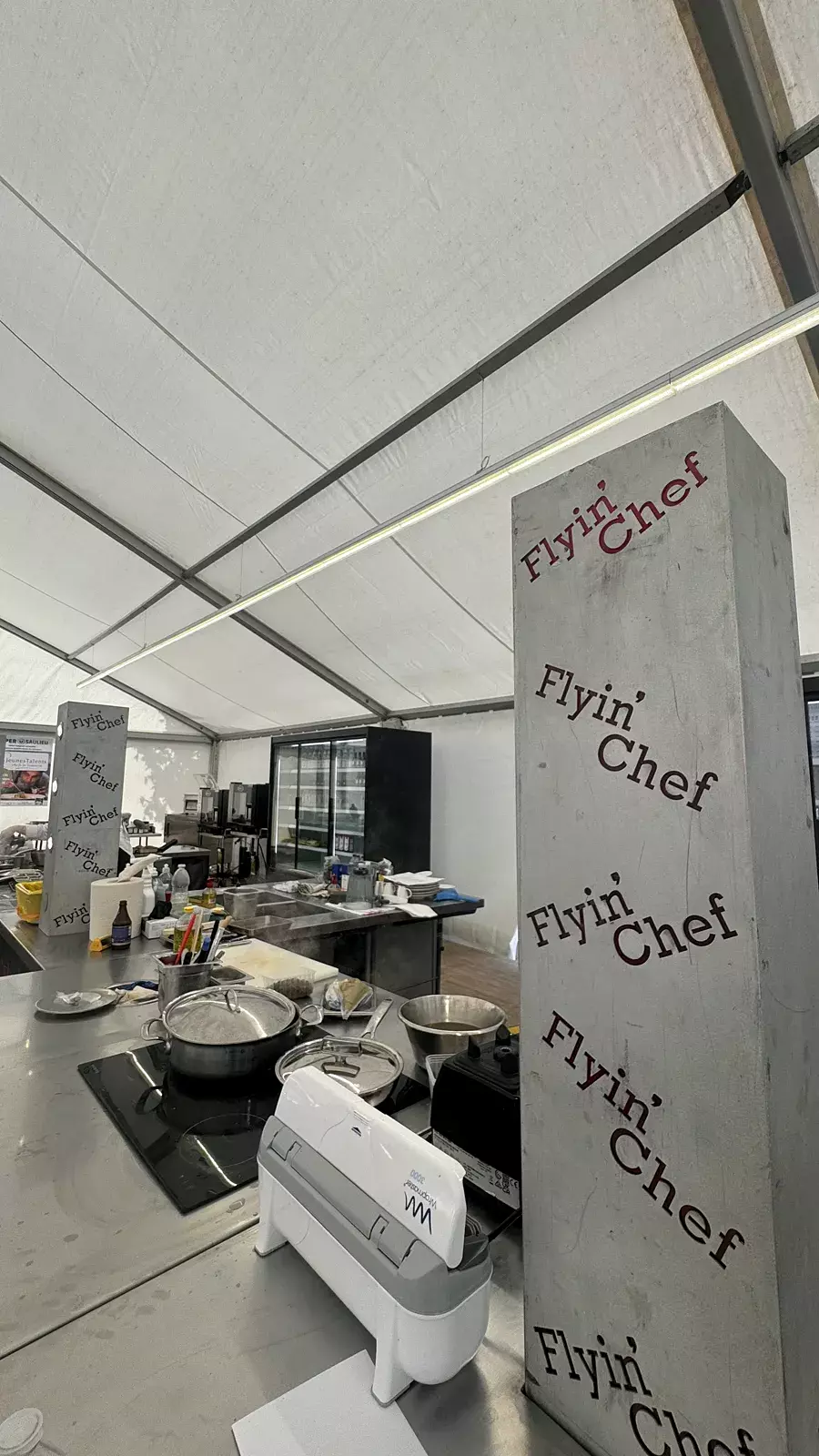 Postes de cuisine Flyin'Chef en inox avec plaques à induction sous le chapiteau du Concours Jeunes Talents à Saulieu