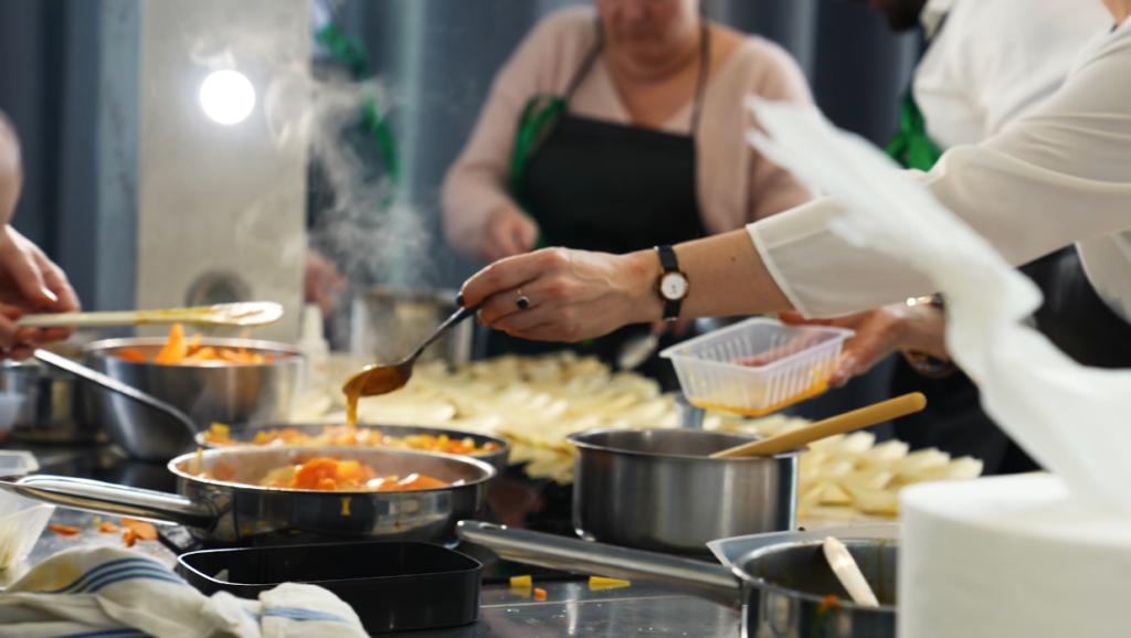 Dégustation commentée : une main verse une sauce sur une préparation lors d'une animation culinaire Flyin'Chef