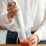 Mixeur plongeant tenu en main pour mixer une préparation dans un bécher
