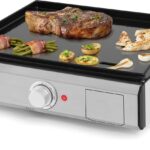 Plancha pro en cuisson avec une pièce de viande, des asperges et des champignons sur la plaque