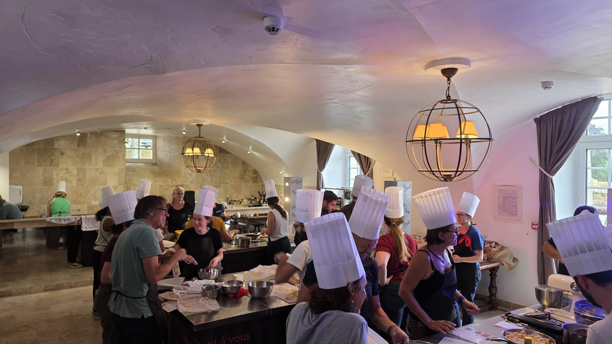 Collaborateurs en toque de chef lors d'un team building pâtisserie dans la salle voûtée du Château de Villers-Bocage